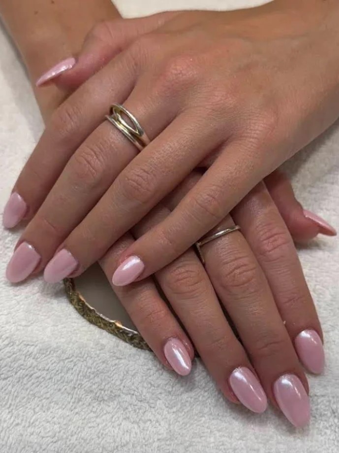 Plano aproximado de uma manicure BIAB rosa cintilante num salo