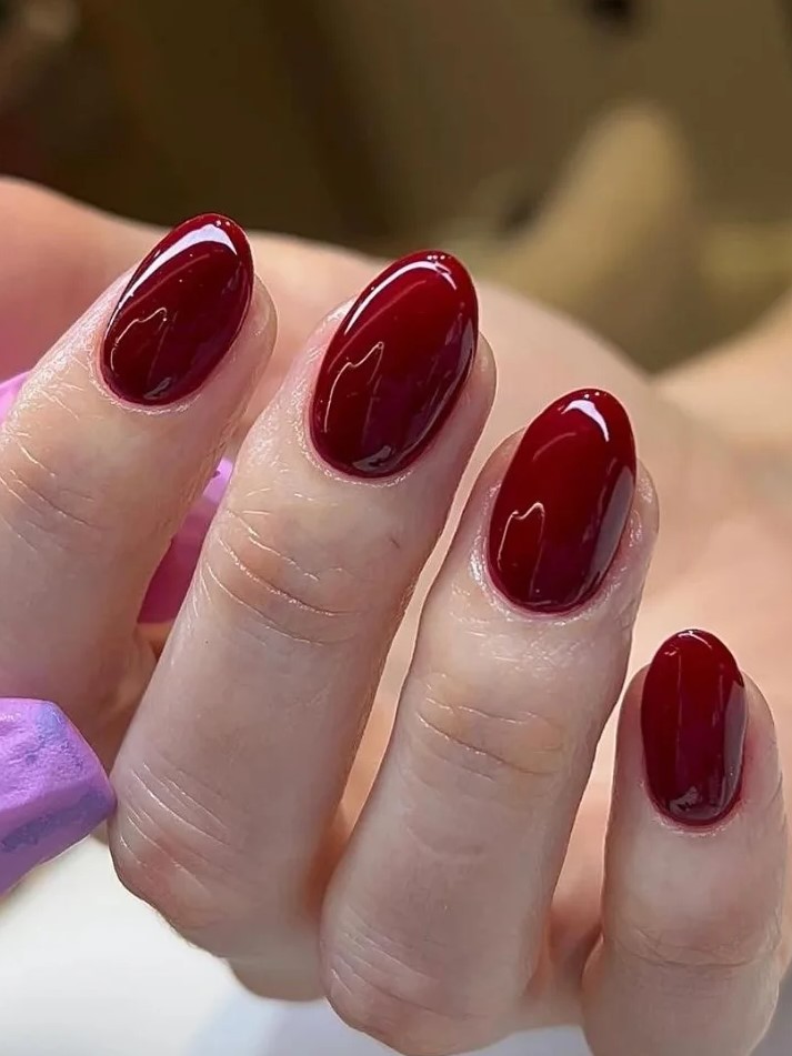 Plano aproximado de uma manicure BIAB em vermelho escuro