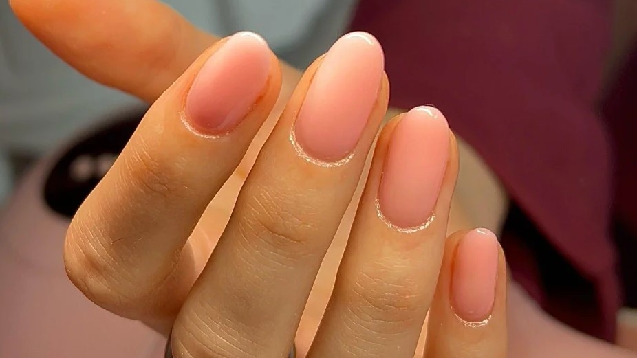 Plano aproximado de uma manicure BIAB em rosa transparente