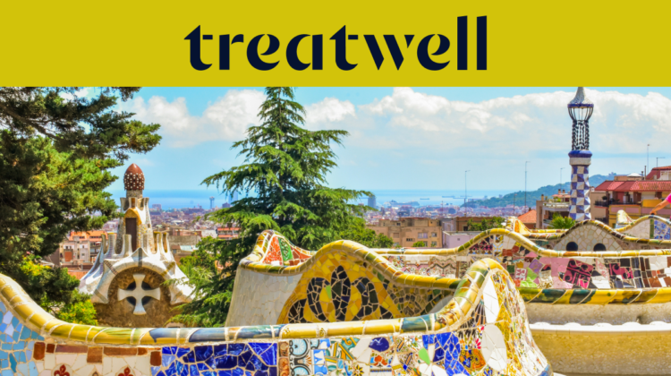 Uma vista panormica de Barcelona a partir do Parque Güell, apresentando os icónicos bancos de mosaico coloridos de Antoni Gaudí e as torres de estilo de conto de fadas em primeiro plano, com a cidade e o mar ao fundo. Um banner amarelo no topo exibe o logótipo "treatwell".
