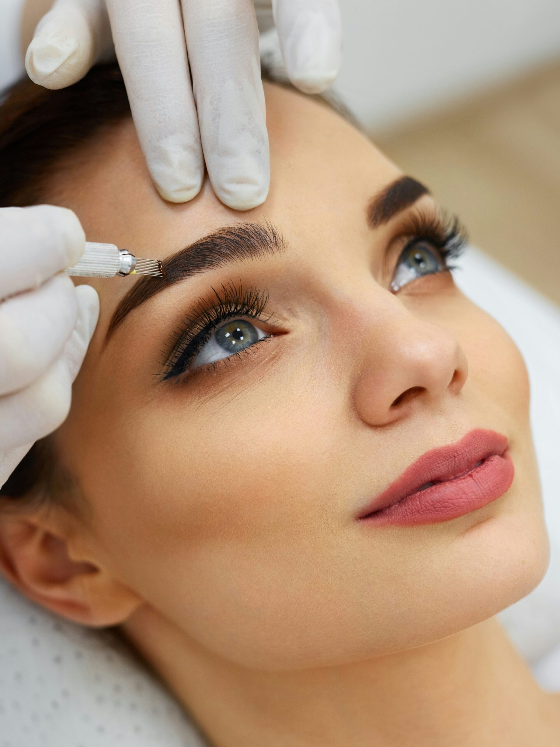 Close-up do rosto de uma mulher num salão a receber um tratamento de microblading