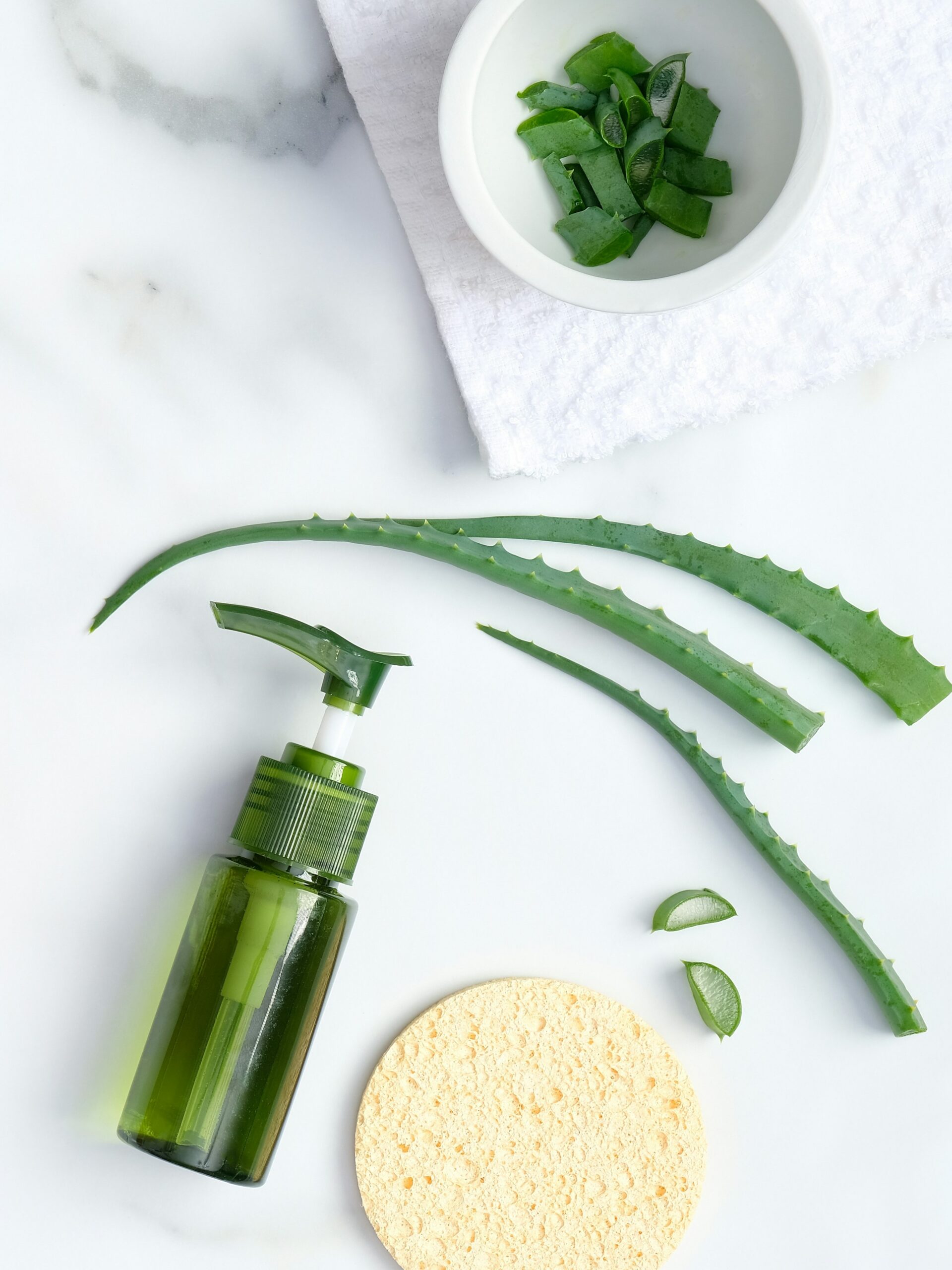 Flat lay de produto calmante de aloe vera com aloe vera natural e uma esponja