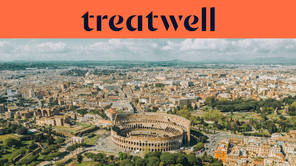 Vista aérea de Roma, com o icónico Coliseu em primeiro plano. A cidade histórica estende-se até ao horizonte sob um céu nublado. Um grande banner laranja no topo exibe o logótipo da Treatwell.