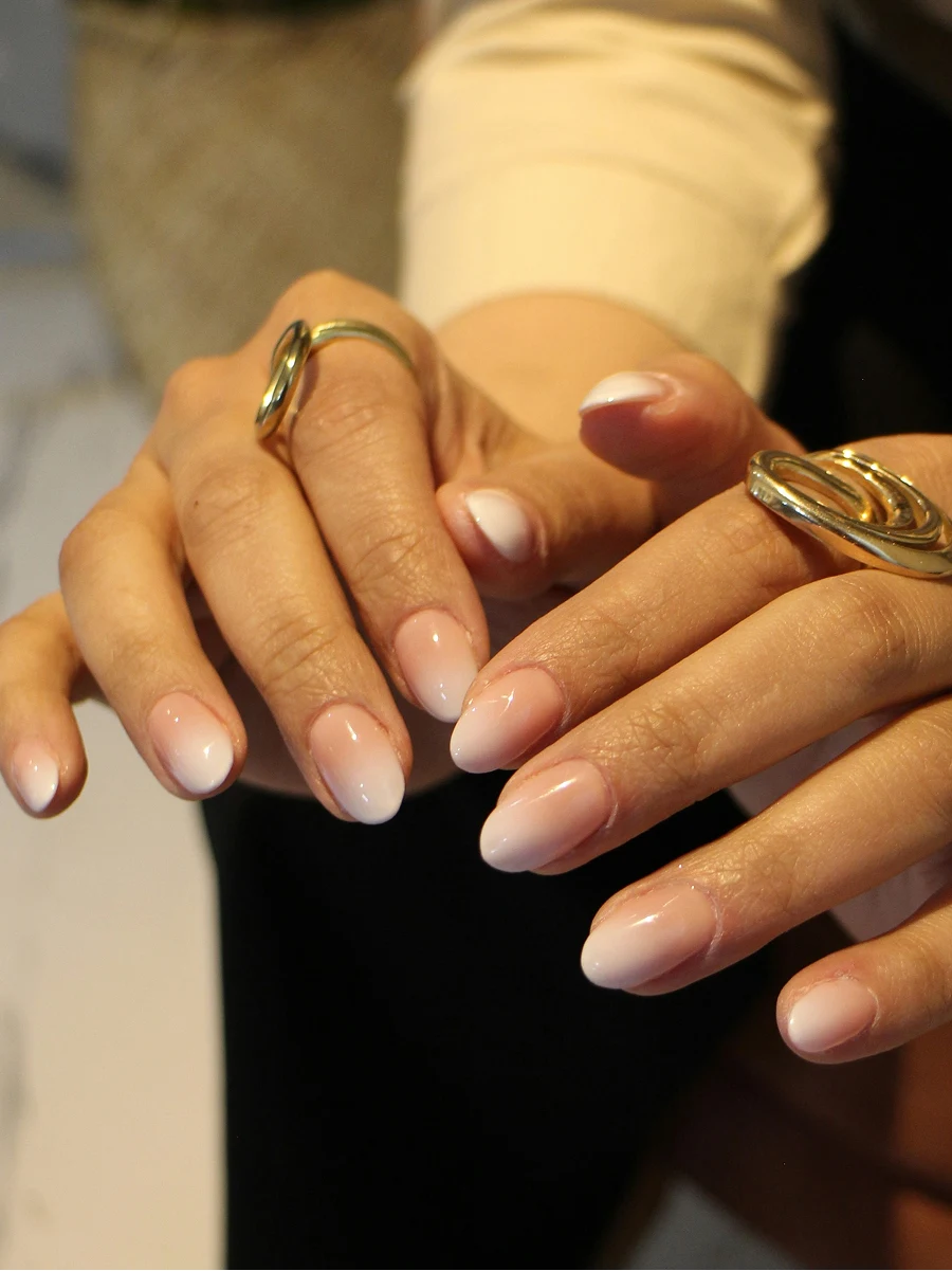 Grande plano de uma manicure ombré em Shellac, em tons nude clássicos, logo a seguir à manicure no salão