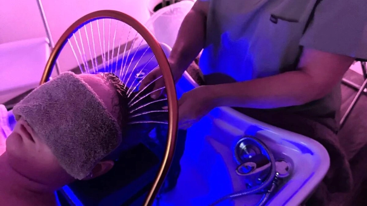 Vista de cima de um terapeuta a lavar o cabelo de uma cliente durante um head spa japonês