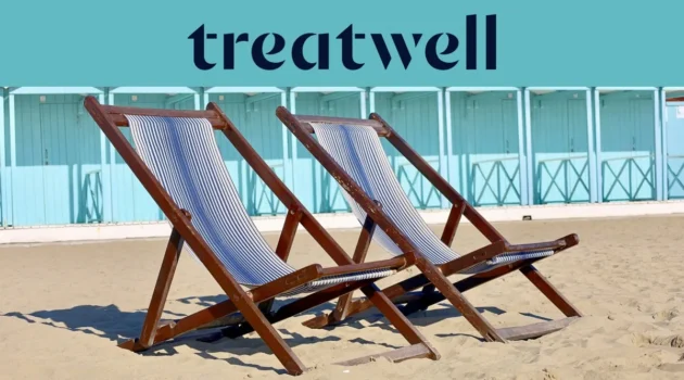 Duas espreguiçadeiras de madeira às riscas na areia em frente a cabanas de praia azul-pastel na costa da Versilia