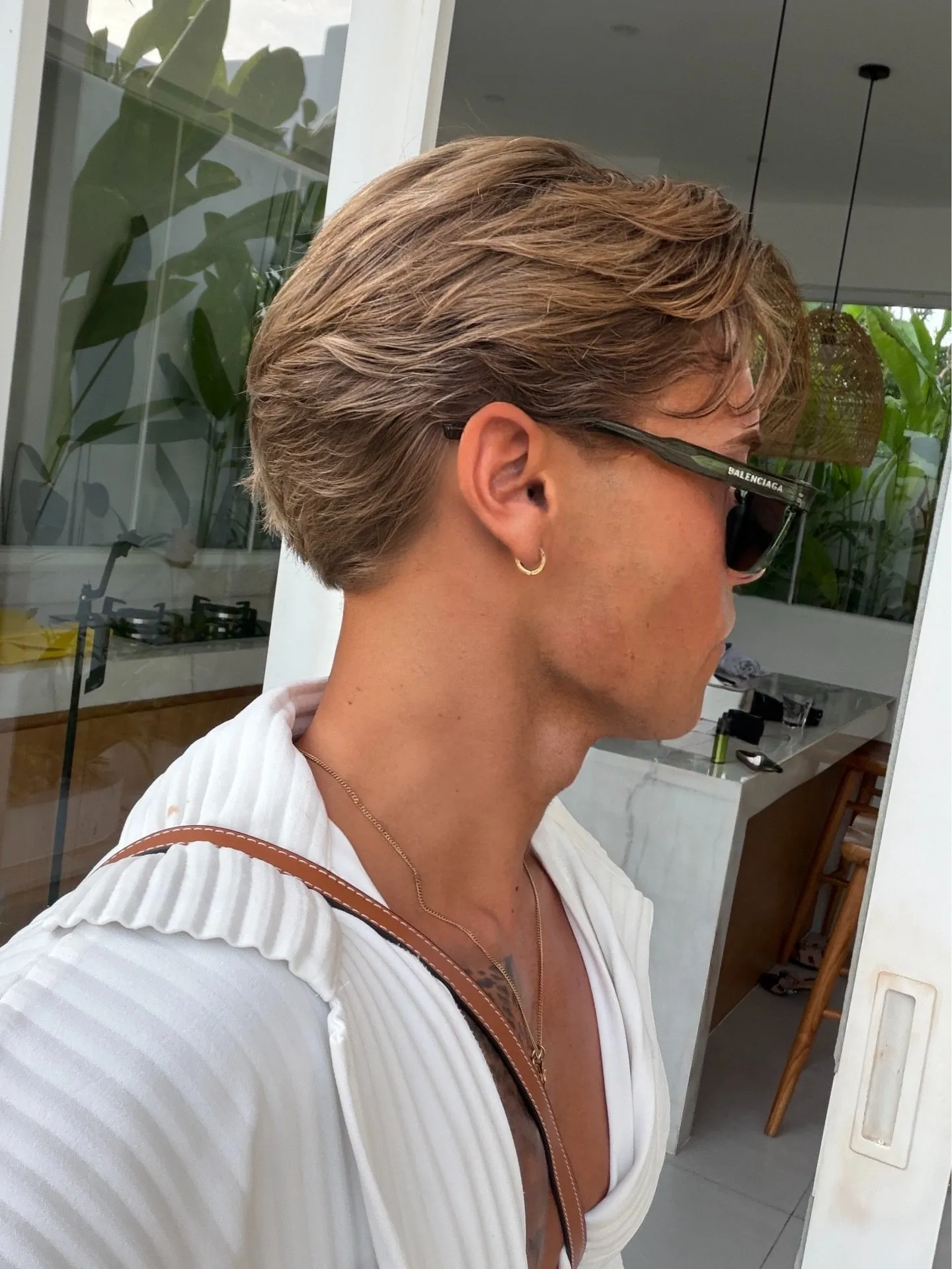 Perfil de um corte masculino flow texturizado, com madeixas penteadas para trás e movimento natural
