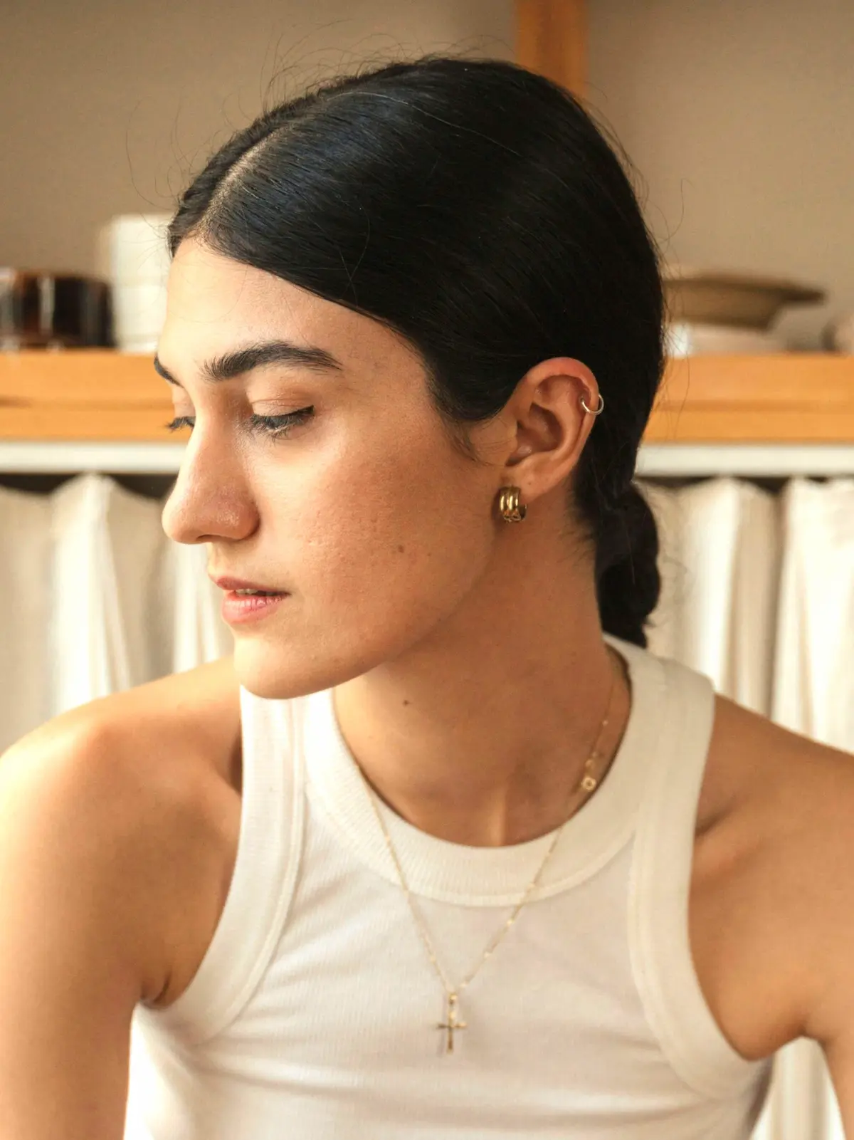 Mulher sentada num banco, com uma argola no piercing da hélice