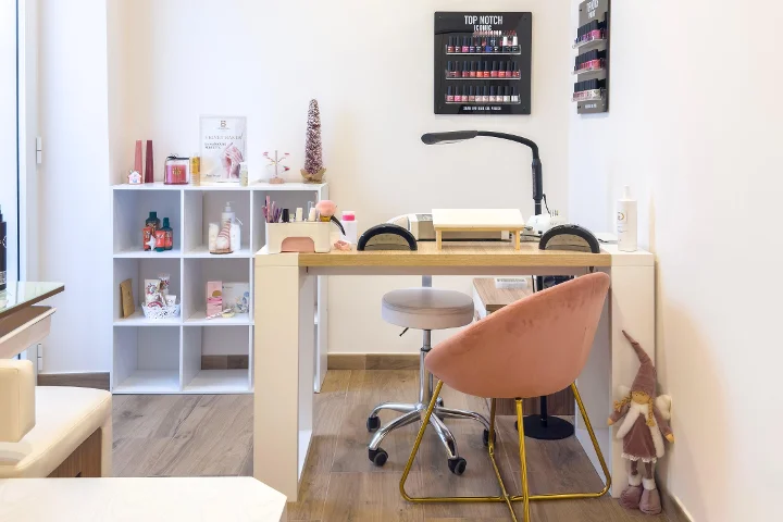 Posto de manicure em Gd Beauty Clinc di Giulia Delogu em Alghero com cadeira de veludo rosa e expositor de vernizes Top Notch.