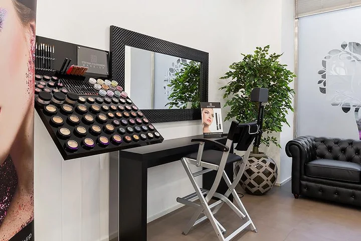 Salão de manicure luminoso Top Estetica em Villanova, Cagliari, com parede turquesa, secretárias florais e pavimentos em mármore.