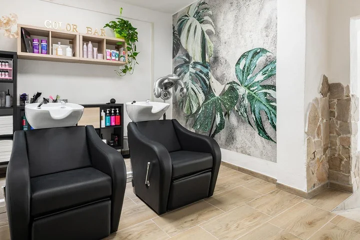 Lava-cabeças e color bar no salão Yourself em Tortolì com um mural de folhas de monstera tropical.
