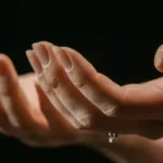 Duas mãos estendidas com as palmas voltadas para cima e unhas a descamar
