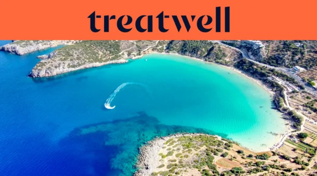 Vista aérea de uma baía cretense turquesa, com uma mota de água a traçar uma curva branca pela água limpa, uma meia-lua de praia de areia e colinas secas ao redor da margem, sob um banner cor de coral com a palavra treatwell.