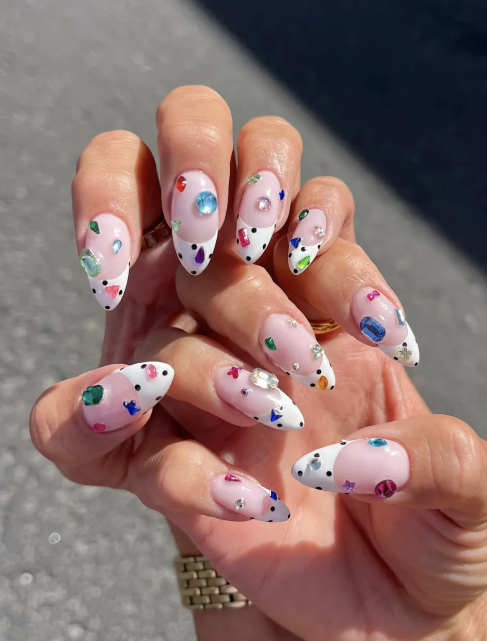 Unhas amendoadas estilo bedazzled com strass coloridos e pontas brancas às bolinhas